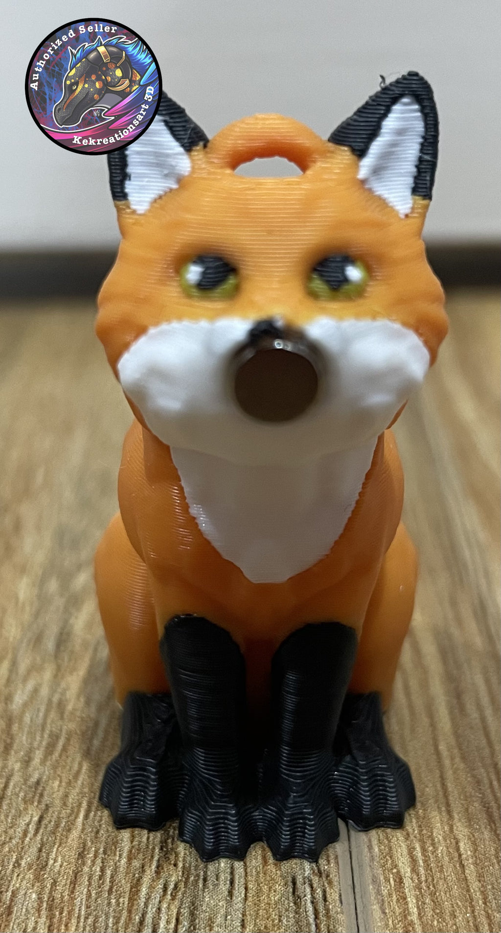 3D-printed fox figurine on a wooden surface. There is a magnet embedded in the front