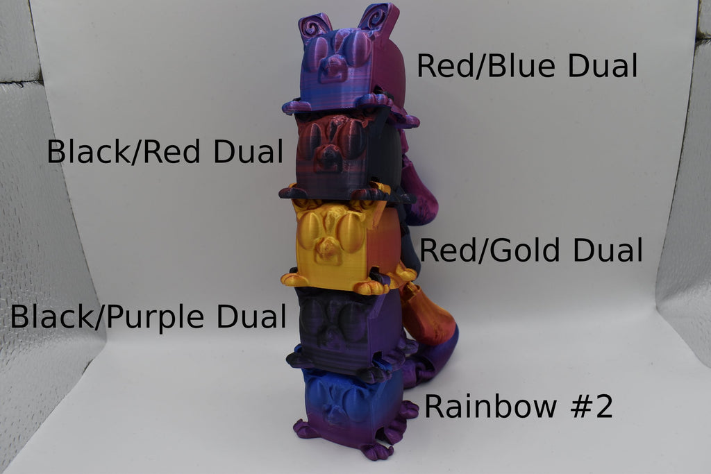 Stack of colorful 5 Sugarcube gliders with labels indicating color combinations on a white background. The labels say "Red/Blue Dual" "Black/Red Dual" "Red/Gold Dual" "Black/Purple Dual" and "Rainbow #2"