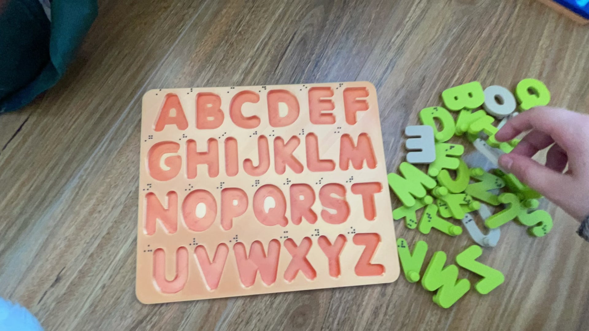 A timelapsed video of a hand putting a letter puzzle together, going from A to Z